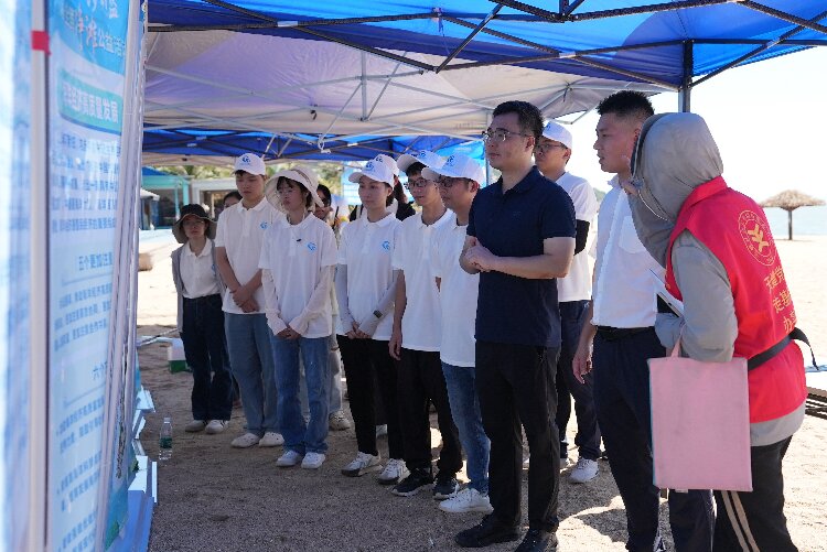 图为领导和志愿者们一起参观净滩活动系列主题展板.jpg